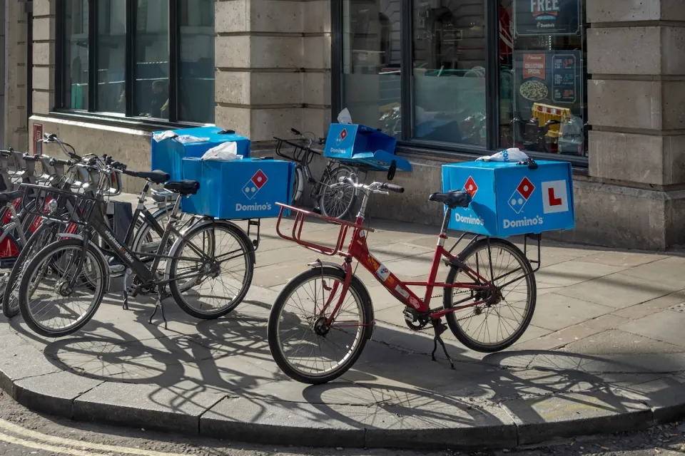 Domino's Pizza delivery bikes parked on a sidewalk in London, UK.